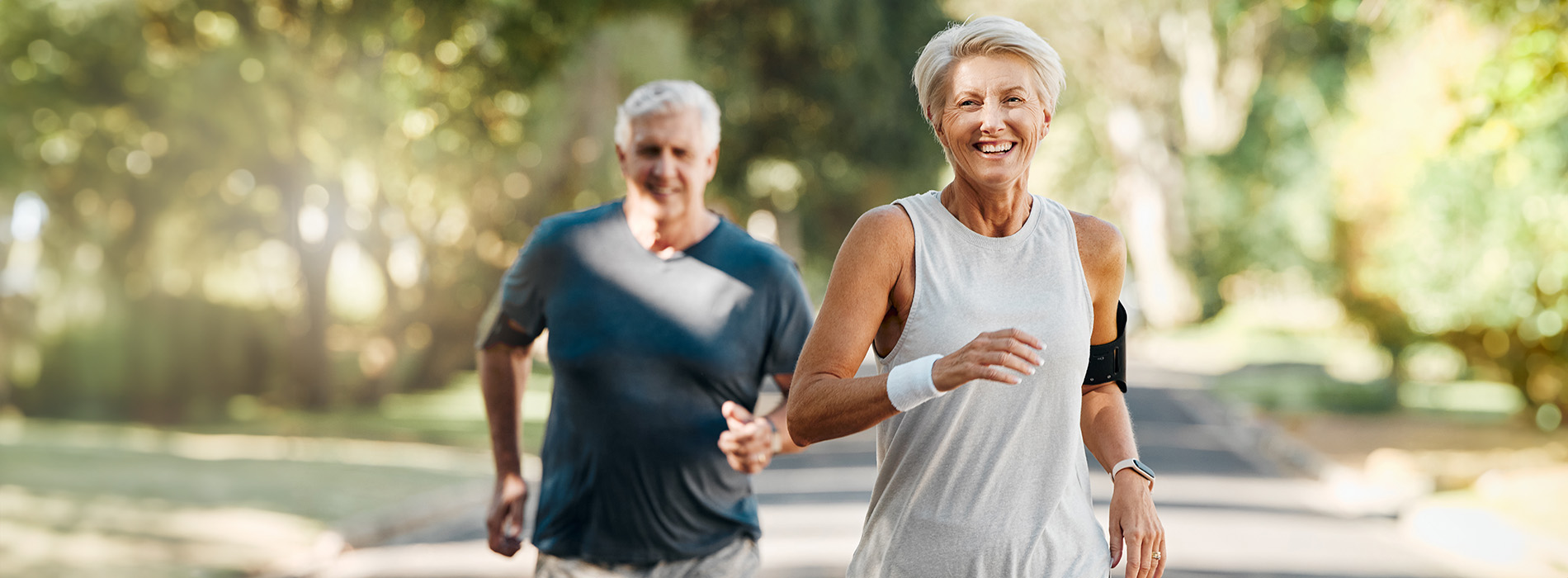 A man and woman jogging side by side on a paved pathway.